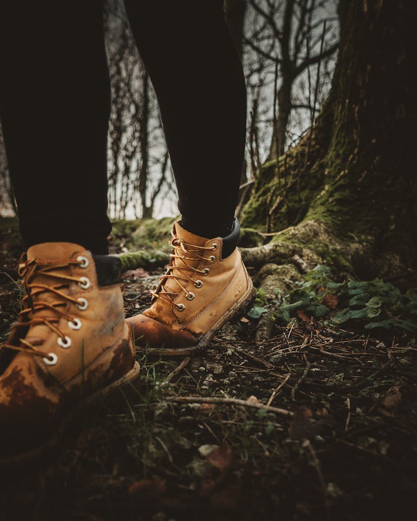 Person Wearing Brown Leather Boots Standing on Brown Dried Leaves